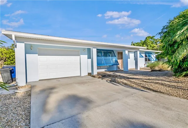 a view of a house with a backyard and a garage