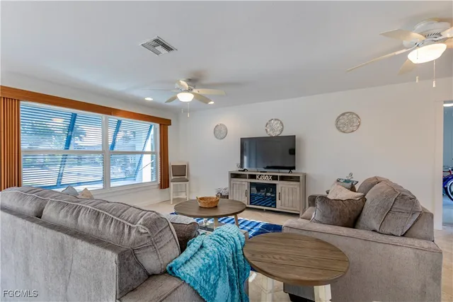 a living room with furniture a flat screen tv and a large window