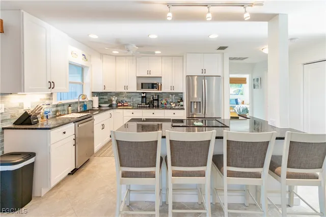 a kitchen with stainless steel appliances kitchen island granite countertop a sink and cabinets