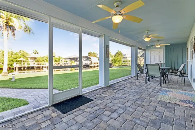 a view of a porch with a table chairs and a backyard
