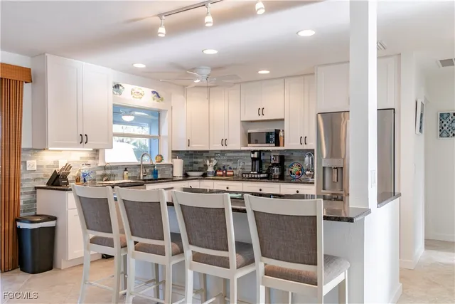 a kitchen with stainless steel appliances granite countertop a refrigerator and a stove top oven