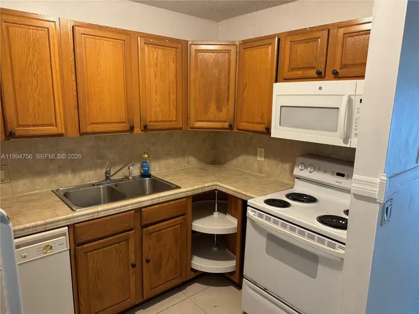 a kitchen with white cabinets and white appliances