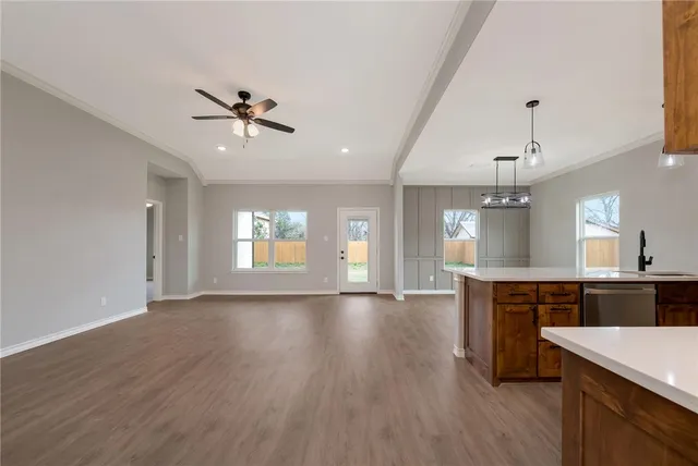 a view of a room with kitchen island hardwood floor and a ceiling fan