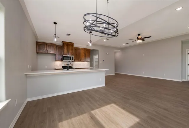 a view of a kitchen with a sink and dishwasher a refrigerator with wooden floor