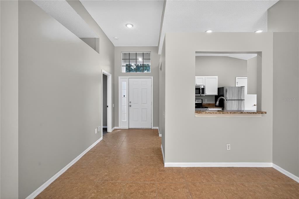 12630 Early Run Lane Riverview, FL 33578 - Photo 3 of 32 an empty room with kitchen view and wooden floor