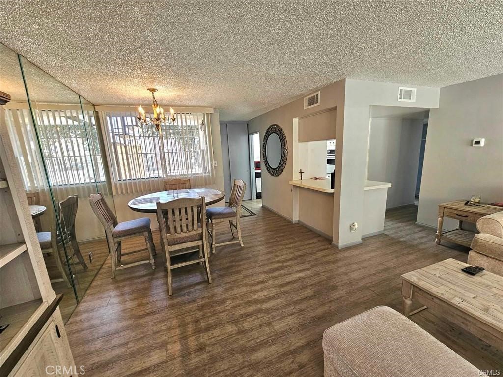 6979 Palm Court, Unit 126H Riverside, CA 92506 - Photo 4 of 25 a dining room with wooden floor and large windows