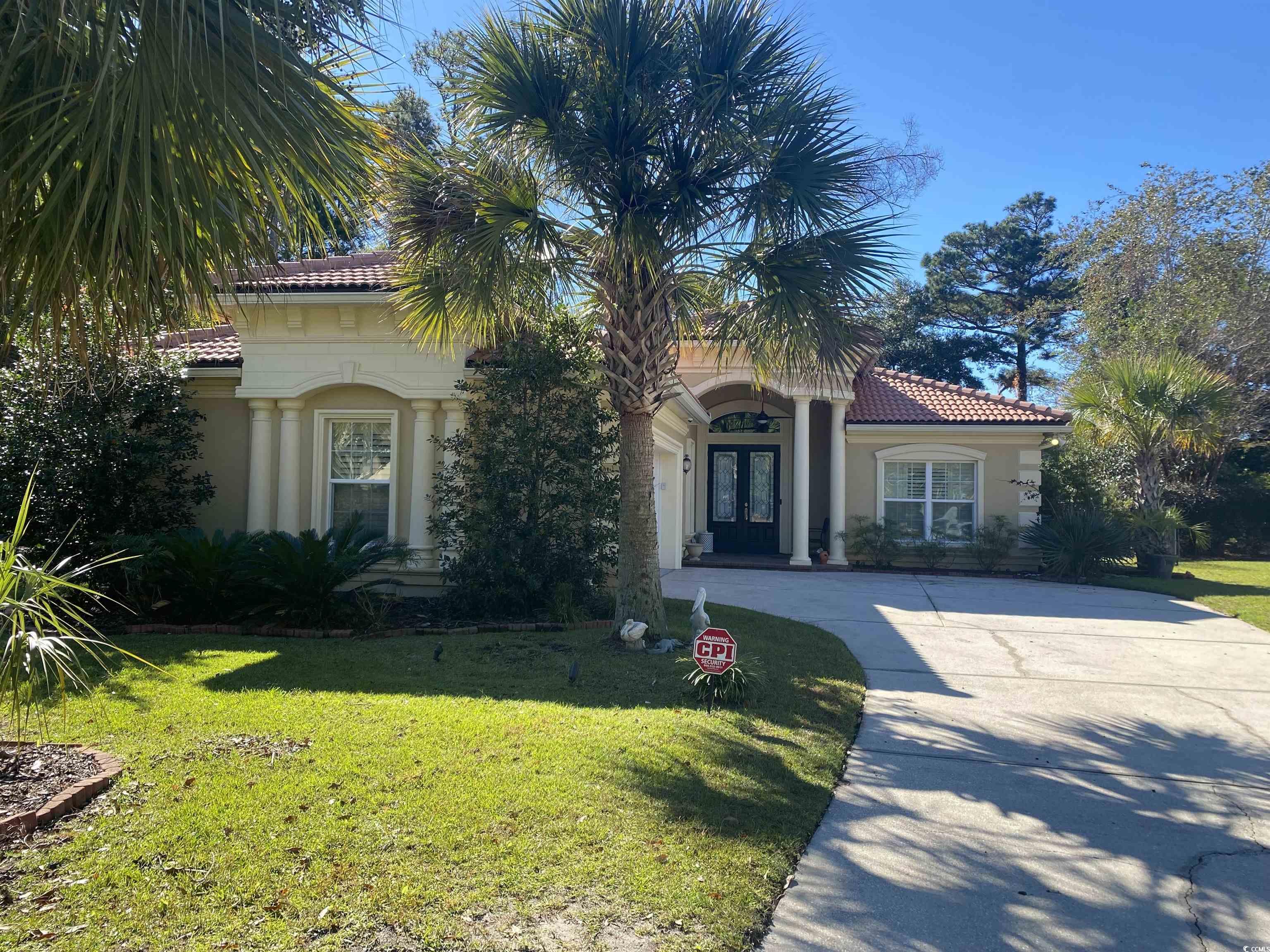 Mediterranean / spanish-style home featuring a front lawn, a tile roof, french doors, and stucco siding