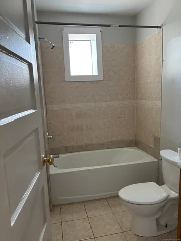 a bathroom with a toilet and a bath tub