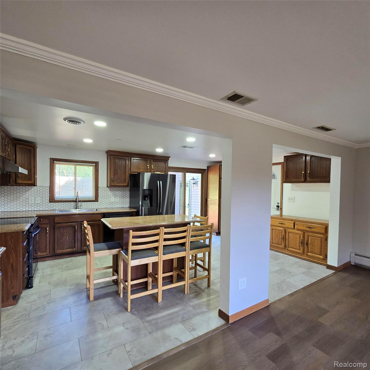 311 Nevada Avenue Rochester, MI 48309 - Photo 19 of 70 Open-concept kitchen featuring wood cabinetry, stone countertops, a hexagonal tile backsplash, and recessed lighting