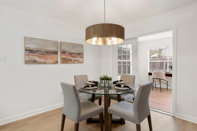 a dining room with furniture a potted plant and a chandelier