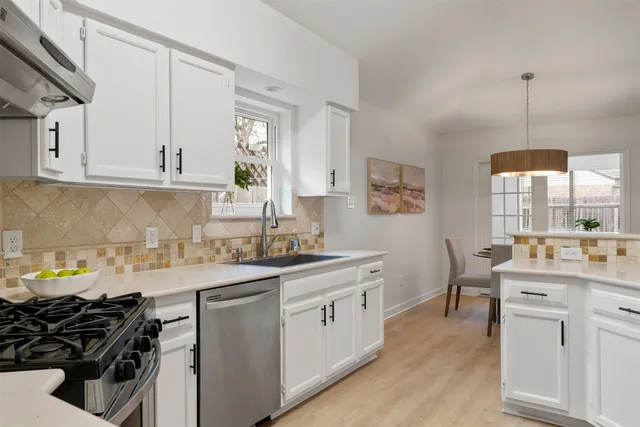 a kitchen with a sink stove and cabinets