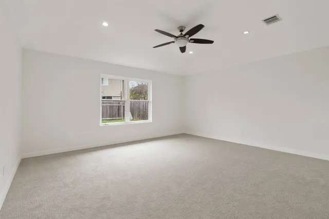 en empty room with windows and ceiling fan view