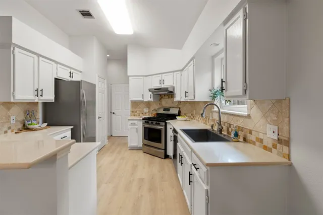 a kitchen with a sink stove and refrigerator