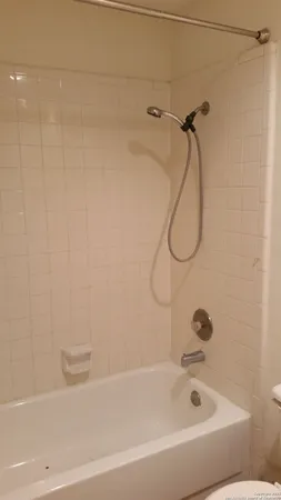 a bathroom with a bath tub with a shower
