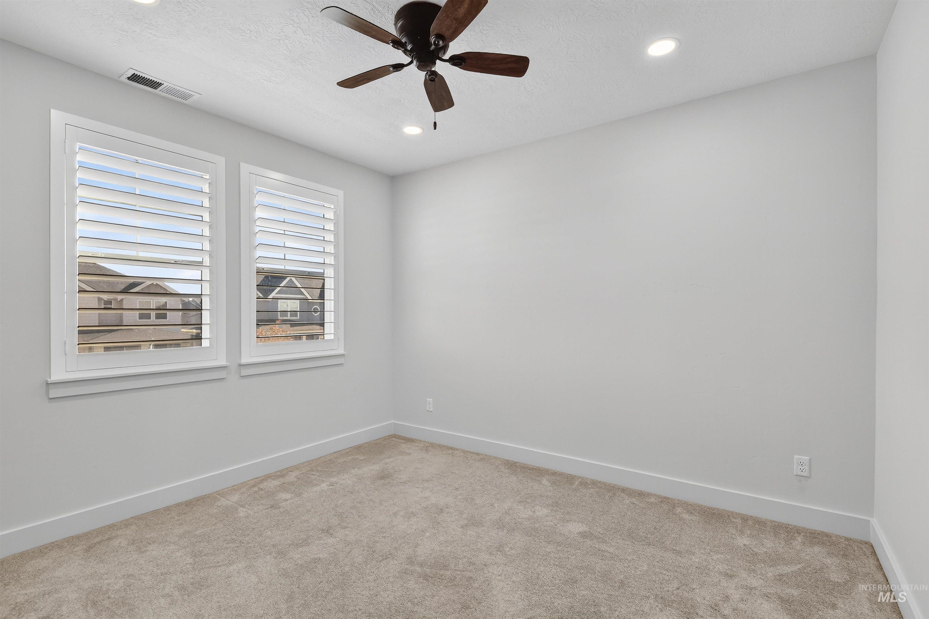6839 North Willowside Avenue Meridian, ID 83646 - Photo 15 of 38 Spare room with carpet, a textured ceiling, ceiling fan, and recessed lighting
