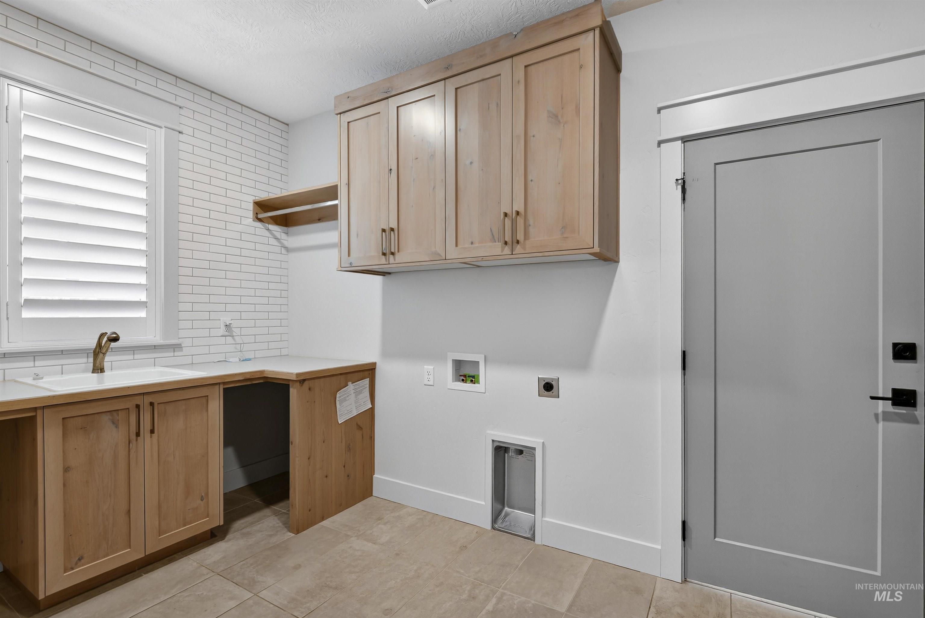 6839 North Willowside Avenue Meridian, ID 83646 - Photo 27 of 38 Washroom with hookup for a washing machine, light tile patterned flooring, electric dryer hookup, and cabinet space