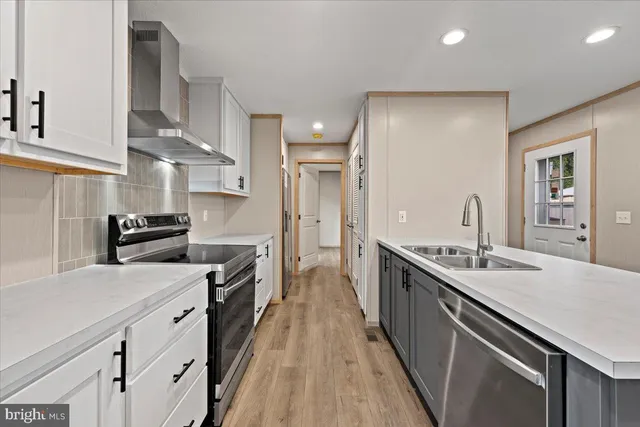 a kitchen with stainless steel appliances a sink stove and cabinets