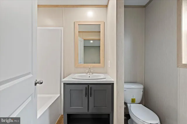 a bathroom with a sink toilet vanity and tub