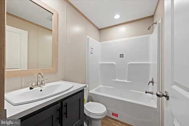a bathroom with a sink a toilet and a large mirror