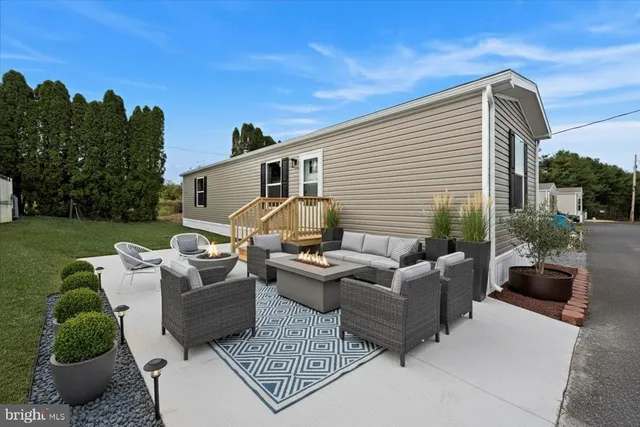 a view of a patio with couches table and chairs with potted plants