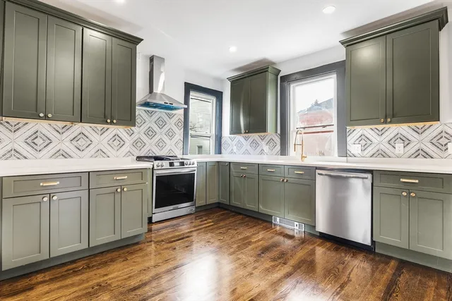 a kitchen with stainless steel appliances granite countertop a sink cabinets and wooden floor