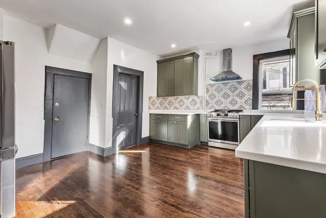 a kitchen with stainless steel appliances granite countertop a sink and a stove top oven