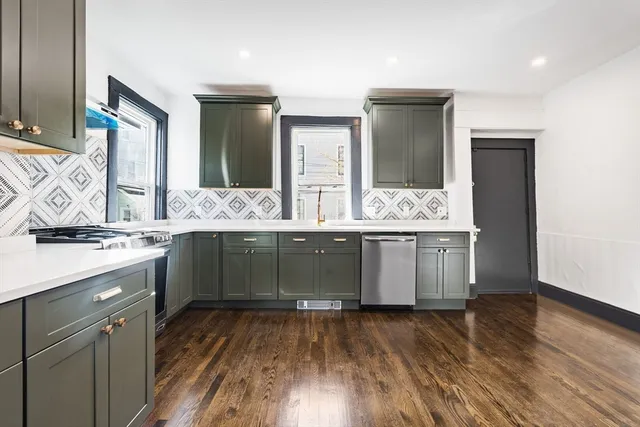a kitchen with a sink and wooden floor