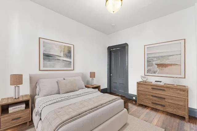 a bedroom with a bed and a painting on the wall