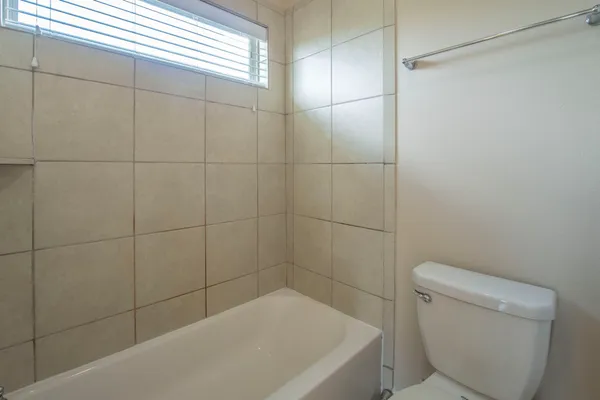 a bath tub sitting next to a toilet and a shower