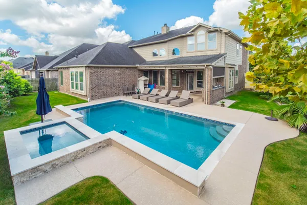 a view of a house with swimming pool and a yard
