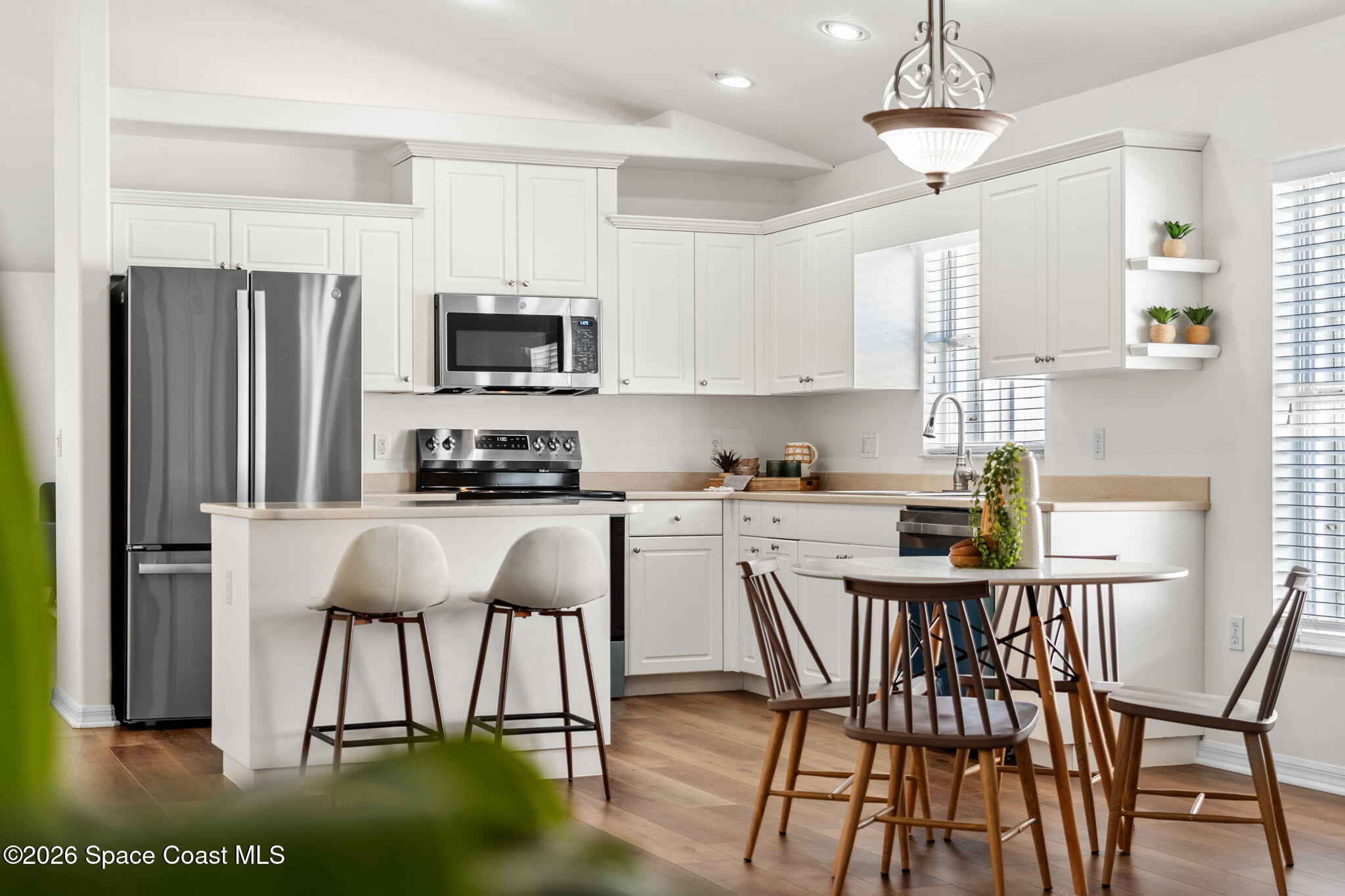 1634 Timacuan Drive Melbourne, FL 32940 - Photo 16 of 77 a kitchen with stainless steel appliances granite countertop a dining table chairs refrigerator and microwave