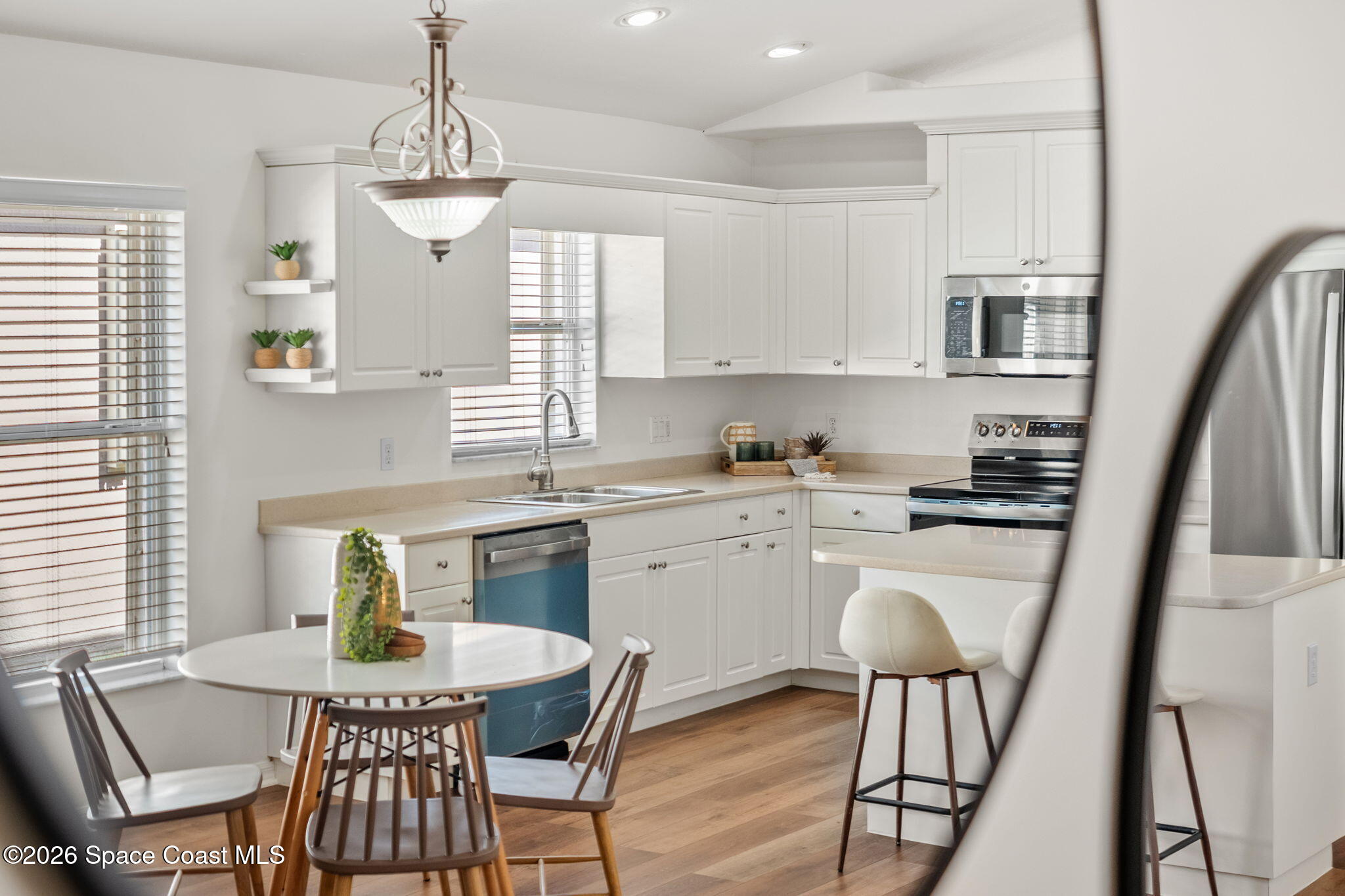 1634 Timacuan Drive Melbourne, FL 32940 - Photo 30 of 77 a kitchen with stainless steel appliances a dining table chairs and a refrigerator