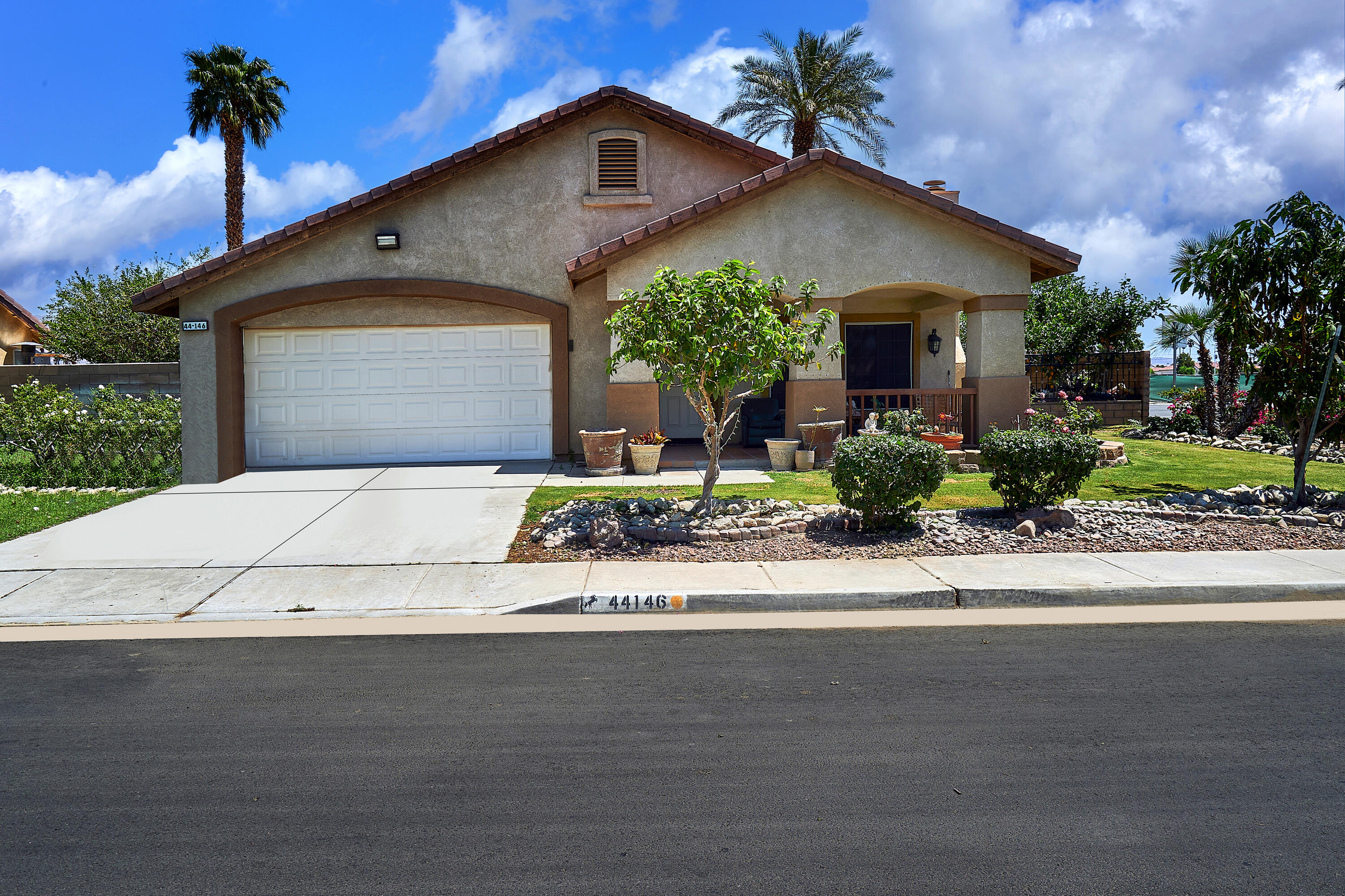 44146 Cassia Drive Indio, CA 92201 - Photo 2 of 20 a front view of a house with a yard and a garage