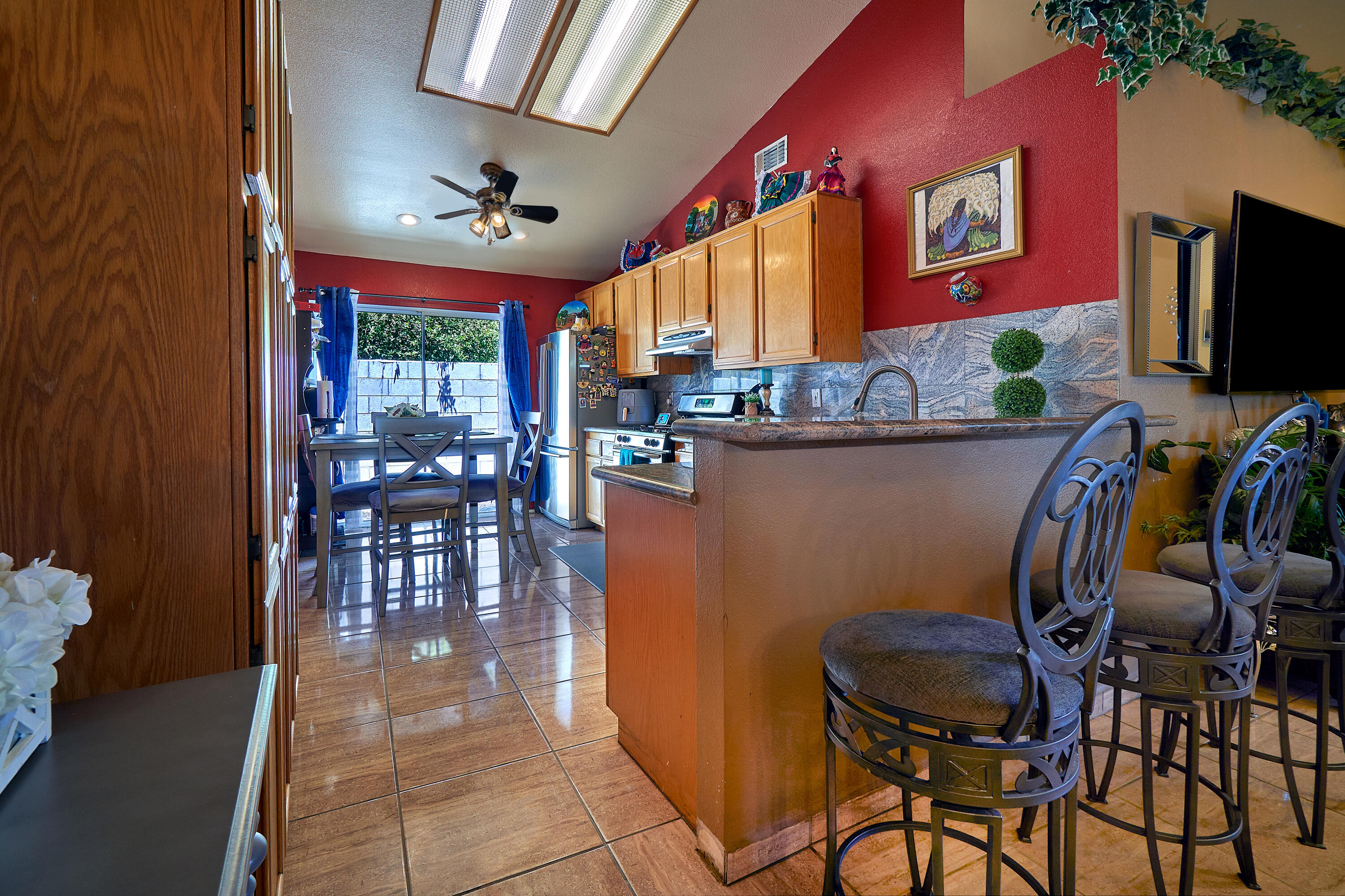 44146 Cassia Drive Indio, CA 92201 - Photo 8 of 20 a dining room with furniture a floor to ceiling window and a flat screen tv
