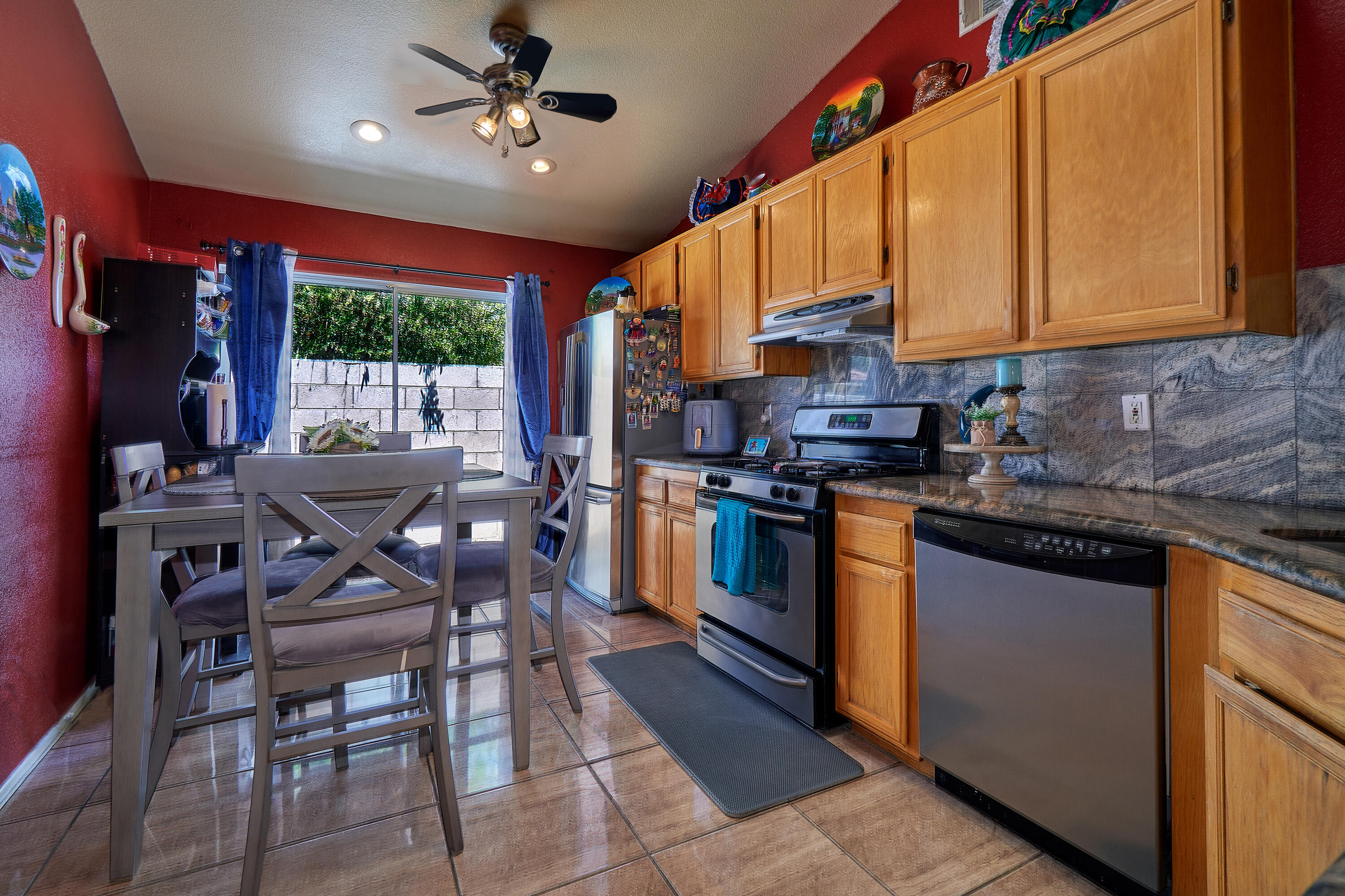 44146 Cassia Drive Indio, CA 92201 - Photo 9 of 20 a kitchen with stainless steel appliances kitchen island granite countertop a stove a sink dishwasher and a microwave oven with cabinets