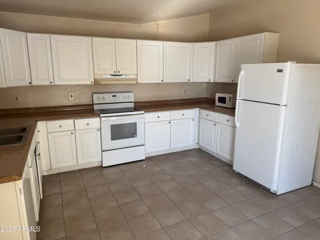 a kitchen with cabinets and white appliances