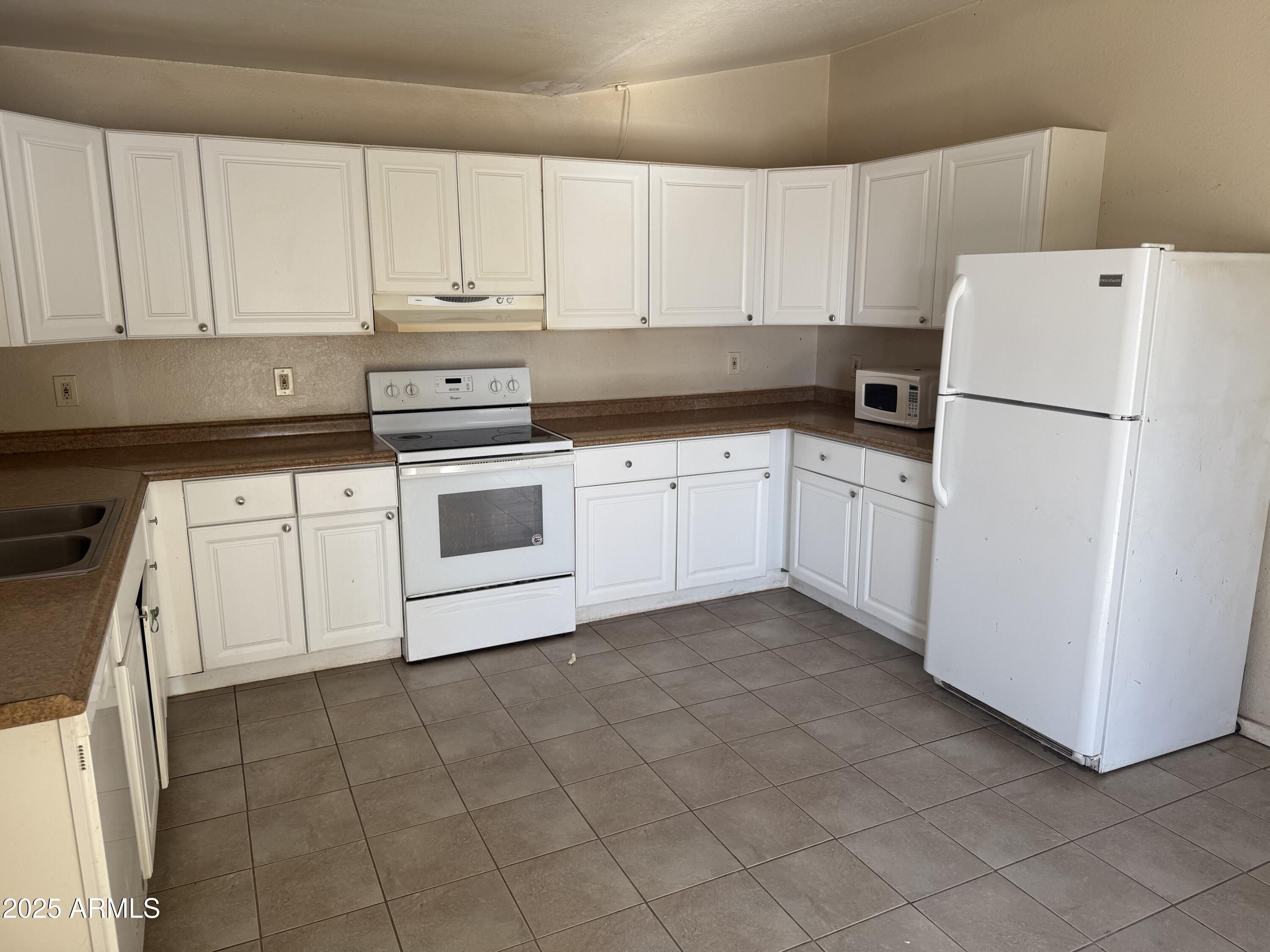 11020 East University Drive Apache Junction, AZ 85120 - Photo 5 of 9 a kitchen with cabinets and white appliances