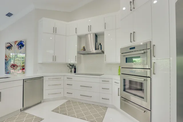 a kitchen with white cabinets and window