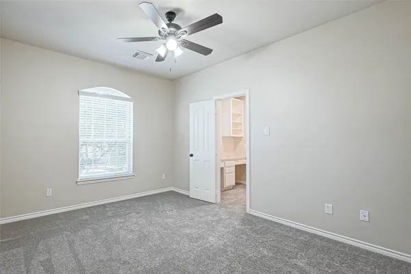 an empty room with chandelier fan