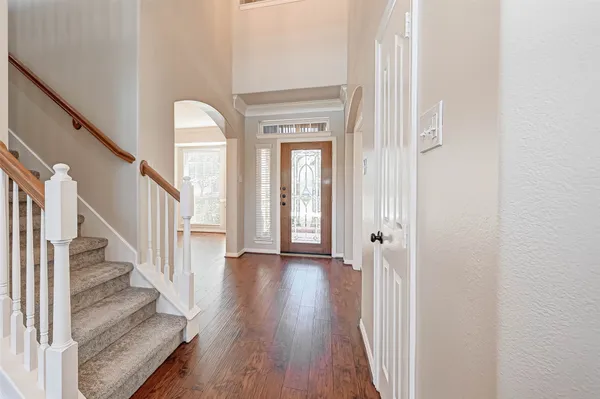 a view of a hallway with wooden floor and staircase