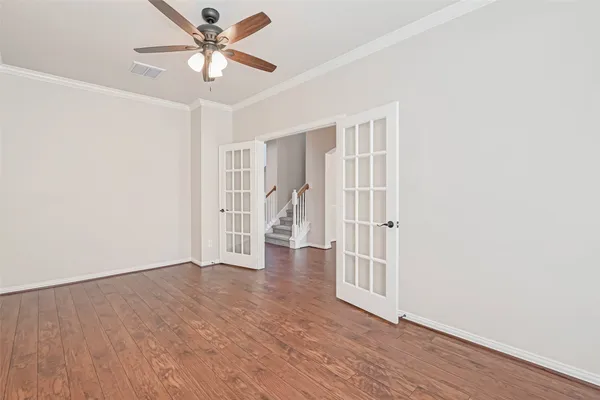 an empty room with wooden floor fireplace and windows