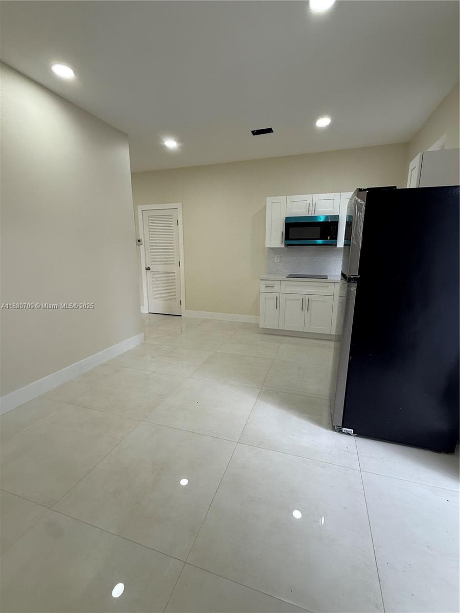559 Northwest 2nd Street, Unit 2 Florida City, FL 33034 - Photo 3 of 8 a view of a refrigerator in kitchen and an empty room