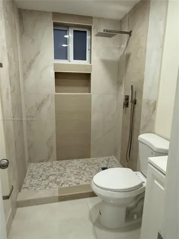 a bathroom with a toilet and a shower