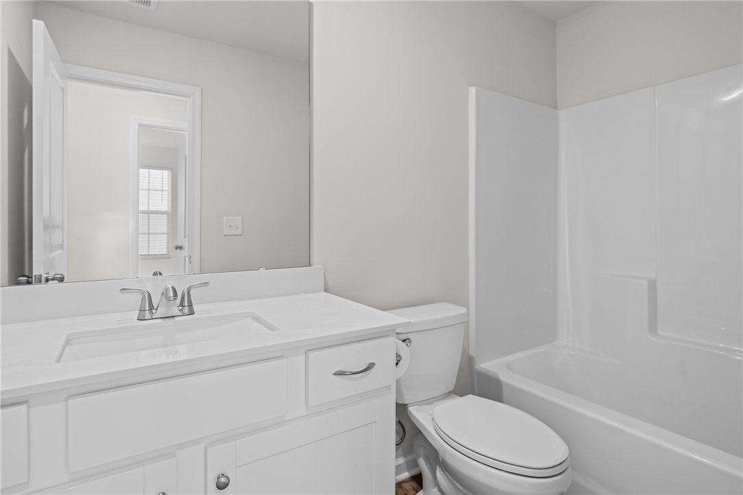 516 Brasstown Court Pendleton, SC 29670 - Photo 21 of 23 This bright bathroom features a vanity, toilet, and a bathtub with shower.