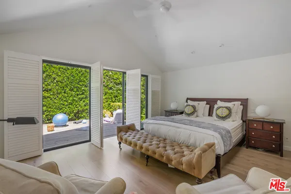 a bedroom with a bed and glass walk in closet