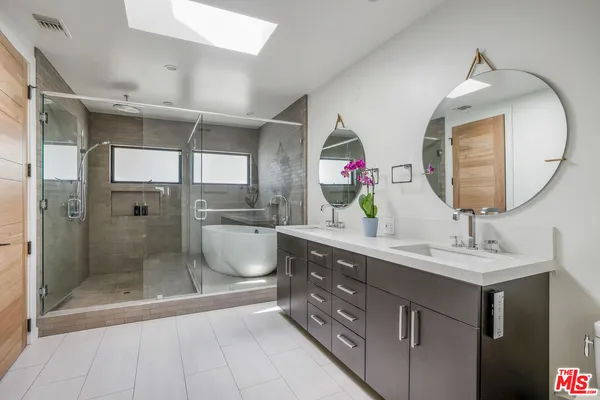 a bathroom with a double vanity sink mirror and shower