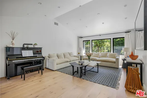 a living room with furniture and a piano