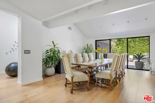 a dining room with furniture and floor to ceiling window