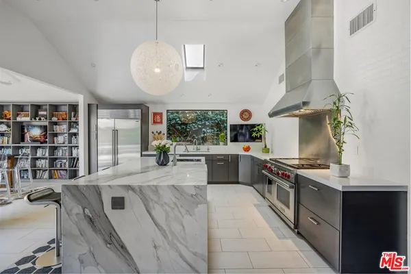 a kitchen with stainless steel appliances granite countertop a stove a sink and a wooden cabinets