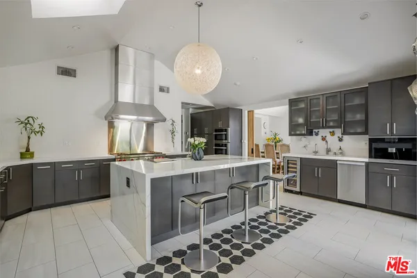 a kitchen with stainless steel appliances kitchen island granite countertop a sink counter space cabinets and a stove